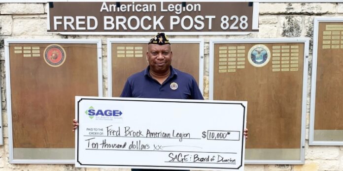 Post Commander Burrell Parmer of Fred Brock American Legion Post No. 828 with $10,000 presentation check provided by San Antonio Growth on the Eastside (SAGE). Photo: Lindsay Logan,SAGE