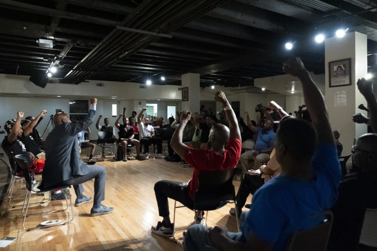 Panelists and attendees raise their fists during a Black Man Lab meeting to discuss the candidacy of Vice President Kamala Harris, Monday, July 22, 2024, in Atlanta. (AP Photo/Stephanie Scarbrough)