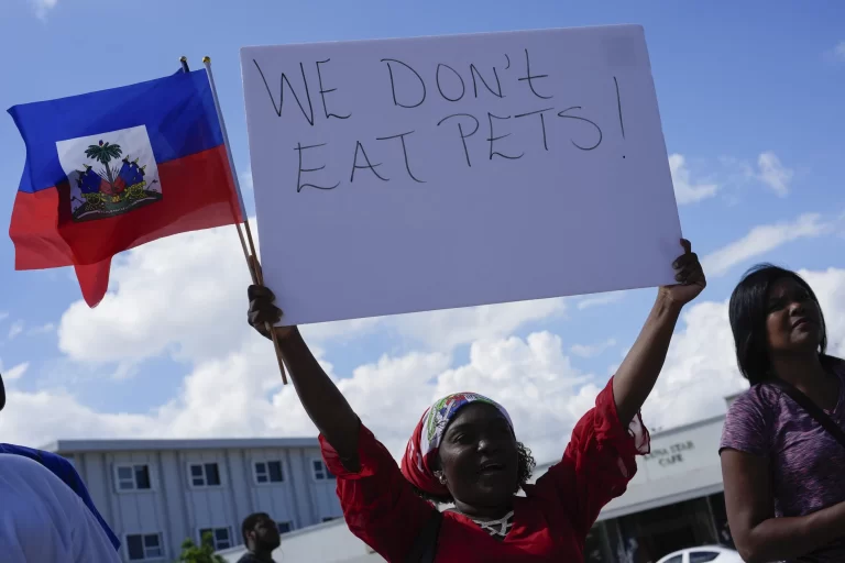 Wilda Brooks of West Palm Beach, Fla., holds up a sign reading “We don’t eat pets,” during a rally by members of South Florida’s Haitian-American community to condemn hate speech and misinformation about Haitian immigrants, Sunday, Sept. 22, 2024, in North Miami, Fla. (AP Photo/Rebecca Blackwell)