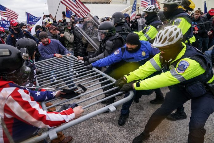 Supporters of Donald Trump, then president of the U.S., try to break through a police barrier at the Capitol in Washington, D.C., on Jan. 6. An internal report by the Capitol Police details many missteps that left the force unprepared for the insurrection that day. (John Minchillo/The Associated Press)