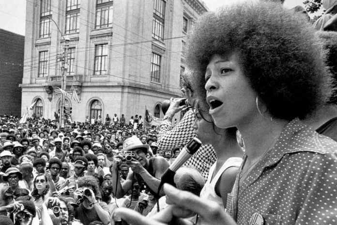 Angela Davis addressing a crowd during the 1970s. Her activism and unjust imprisonment highlight the ongoing struggle and personal sacrifices in the quest for justice. Photo: wsu.edu