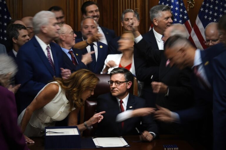 Republican members of Congress reach to shake hands with Speaker of the House Mike Johnson, R-La., center bottom, after Johnson signed the President Donald Trump’s signature bill of tax breaks and spending cuts, Thursday, July 3, 2025, at the Capitol in Washington. (AP Photo/Julia Demaree Nikhinson)