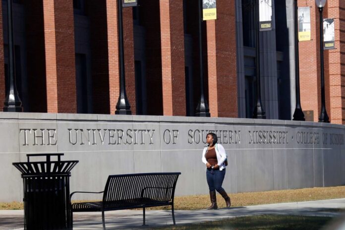 A student walks across the University of Southern Mississippi School of Business in Hattiesburg, Miss., Nov. 21, 2016. AP Photo/Rogelio V. Solis, File