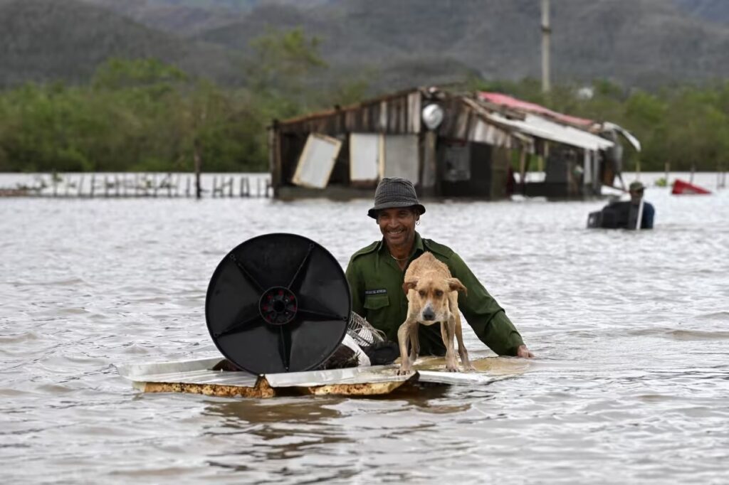 A farmer rescues his dog and some belongings from his flooded house today in San Miguel de Parada, eastern Cuba. Yamil Lage / AFP - Getty Images