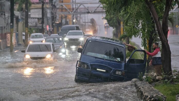 Flooded Kingston street or residents preparing storm shutters — Alt text: Hurricane Melissa Jamaica residents prepare for record-breaking Category 5 storm.