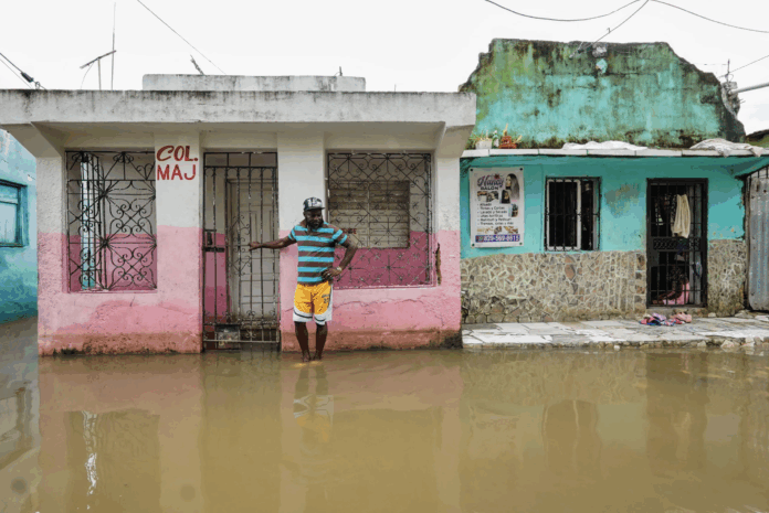 A man stands next to a house on a flooded street after the passing of the tropical storm Melissa before it became a hurricane at Las Cucarachas neighborhood in Santo Domingo, Dominican Republic on Oct. 28, 2025. Danny Polanco/AFP via Getty Images