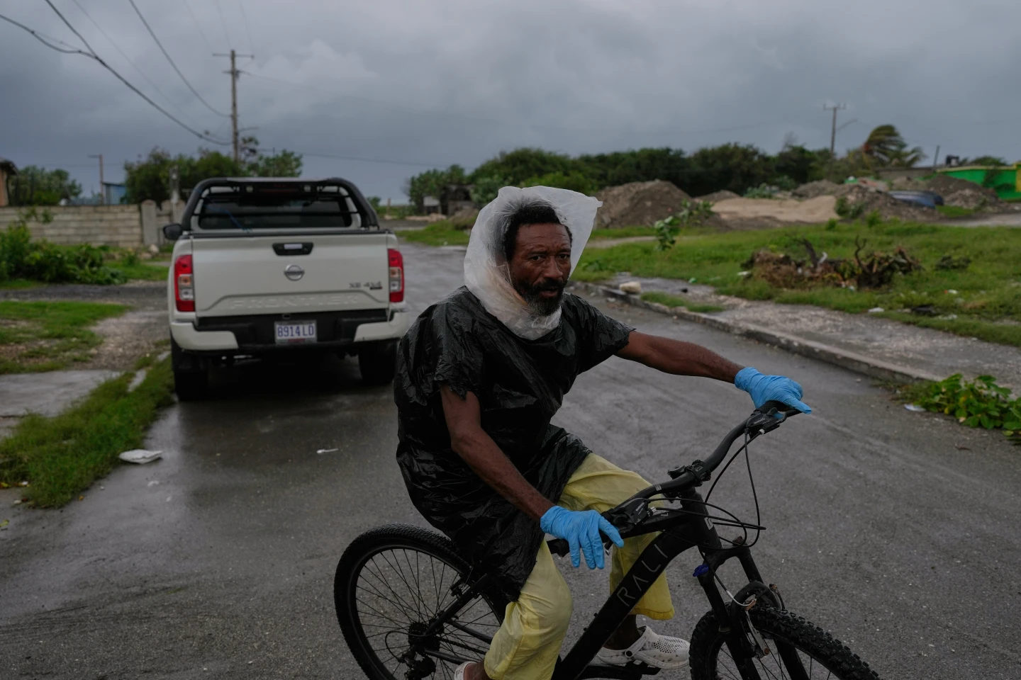 A man rides a bicycle ahead of the forecast arrival of Hurricane Melissa in Kingston, Jamaica, Sunday, Oct. 26, 2025. (AP Photo/Matias Delacroix)

