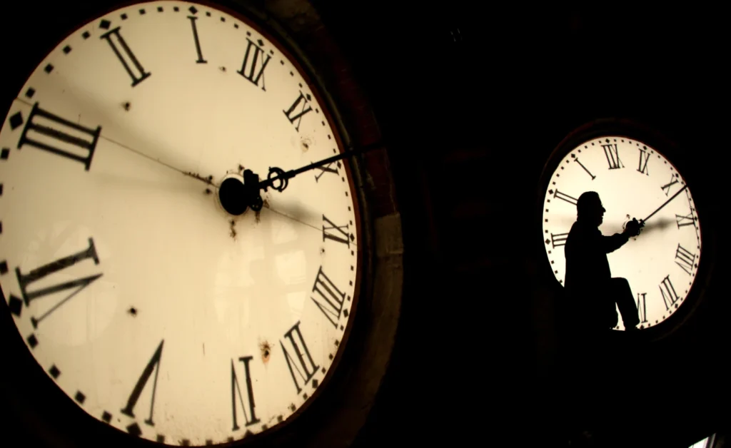 Custodian Ray Keen inspects a clock face before changing the time on the 100-year-old clock atop the Clay County Courthouse March 8, 2014, in Clay Center, Kan. (AP Photo/Charlie Riedel, File)