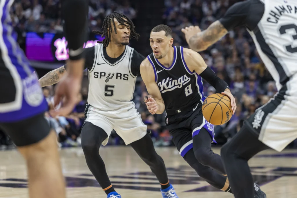Sacramento Kings guard Zach LaVine (8) drives to the basket past San Antonio Spurs guard Stephon Castle (5) during the first half of an NBA basketball game Friday, March 7, 2025, in Sacramento, Calif. (AP Photo/Sara Nevis)
