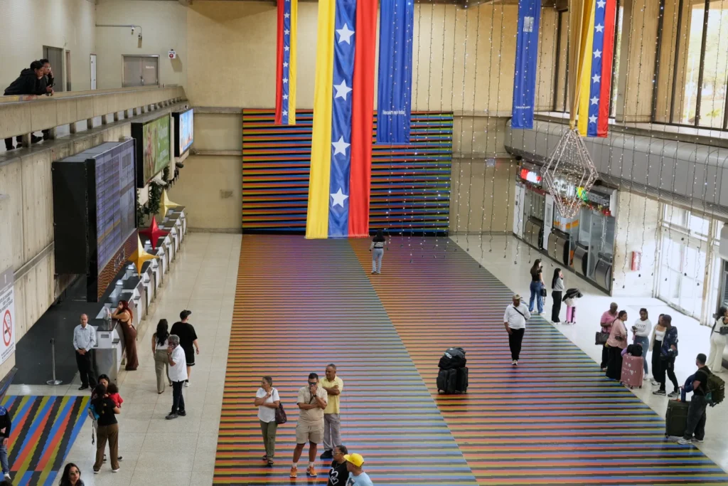 Travelers walt in the main hall of the Simon Bollvar Maiquetia International Airport in Maiquetia, Venezuela, Sunday, Nov. 23, 2025, after several international airlines canceled flights following a warning from the U.S. Federal Aviation Administration about a hazardous situation in Venezuelan airspace. (AP Photo/Ariana Cubillos)