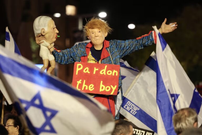 An Israeli anti-government protester dressed up as Trump holds a doll depicting Netanyahu during a demonstration in Tel Aviv on Nov. 15Jack Guez / AFP - Getty Images