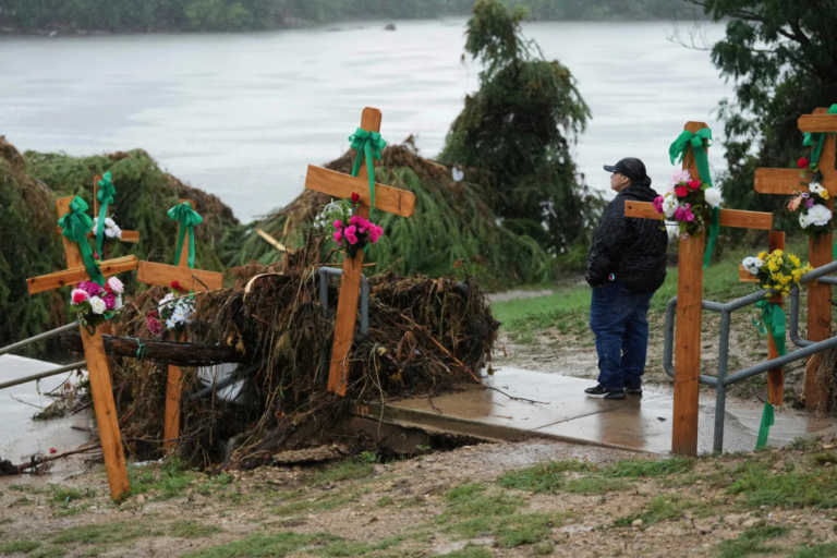 Rain falls as Irene Valdez visits a make-shift memorial for flood victims along the Guadalupe River, Sunday, July 13, 2025, in Kerrville, Texas. (AP Photo/Eric Gay, File)