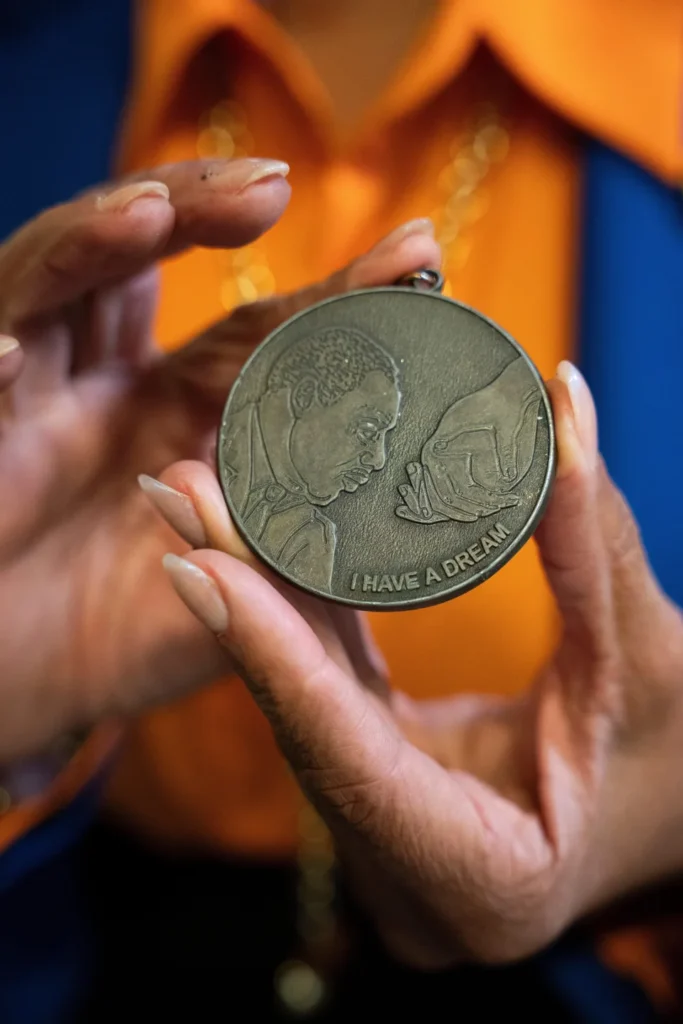 Deborah Scott holds a Martin Luther King Jr. commemorative medallion awarded to her as a symbolic passing of the baton to the next generation of civil rights leaders at The Movement Center, in Atlanta, Sunday, Nov. 30, 2025. (AP
Photo/Olivia Bowdoin)