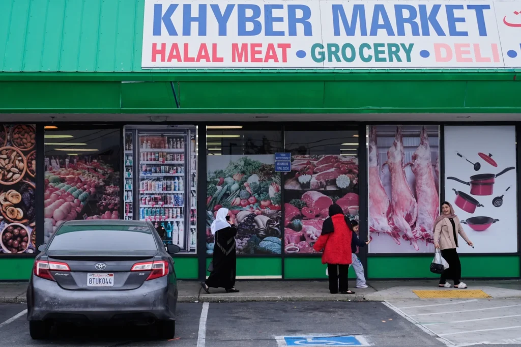 Women and children exit an Afghan grocery store in North Highlands, Calif., Friday, Dec. 5, 2025. (AP Photo/Godofredo A. Vásquez)

