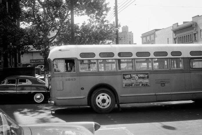A man drives an empty bus through downtown Montgomery, Ala., April 26, 1956, during the Montgomery Bus Boycott. (AP Photo/Horace Cort, File)