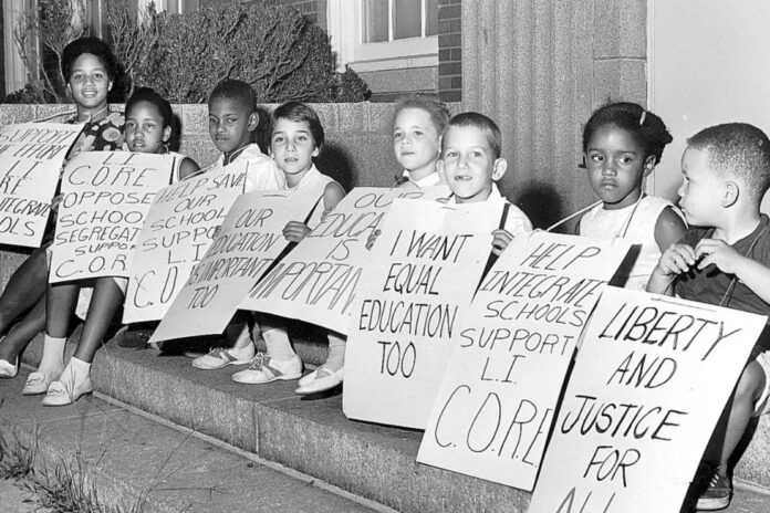 Children sit on the steps of Malverne HIgh School in Malverne, N.Y., in 1962, with picket signs supporting integrated education. Photo: Marvin Sussman/Newsday RM via Getty Images