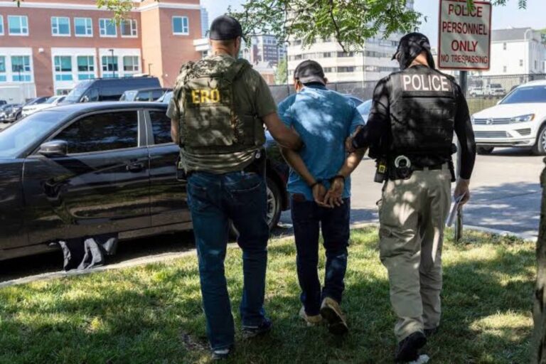 ICE detains a man on the side of the street. JOHN MOORE/GETTY IMAGES