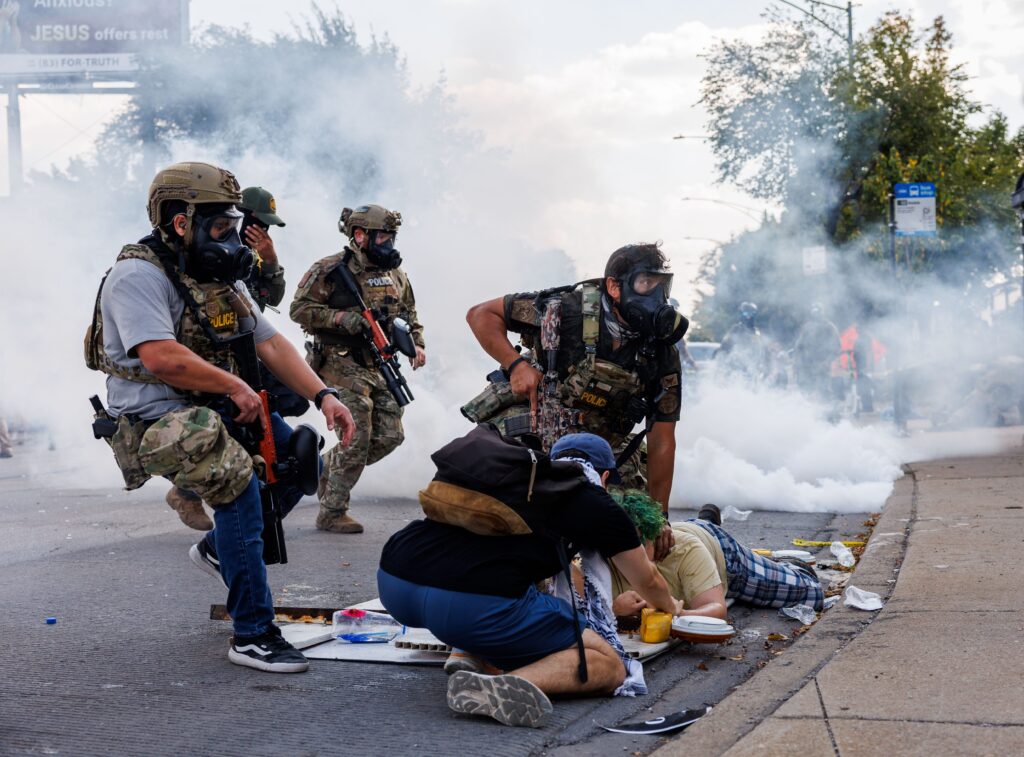 Federal officers detain a person while members of the community and activists protest near the 3900 block of South Kedzie Avenue, Oct. 4, 2025, in Chicago. (Armando L. Sanchez/Chicago Tribune)