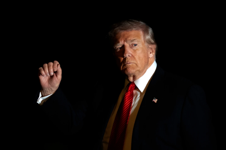 President Donald Trump is illuminated by a camera flash as he gestures while walking across the South Lawn of the White House, Nov. 2, 2025, in Washington, after returning from a trip to Florida. (AP Photo/Mark Schiefelbein, File)
