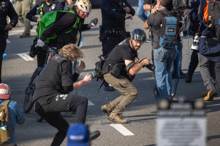 Members of the press take cover as police officers clear the area outside of a federal building as protests continue in Los Angeles on June 9, 2025. Photo by David McNew, Getty Images