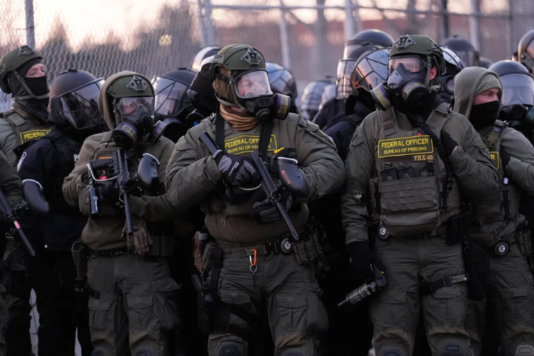 Federal officers stand outside the Bishop Henry Whipple Federal Building during a protest on Saturday, Jan. 17, 2026, in Minneapolis. (AP Photo/Yuki Iwamura)