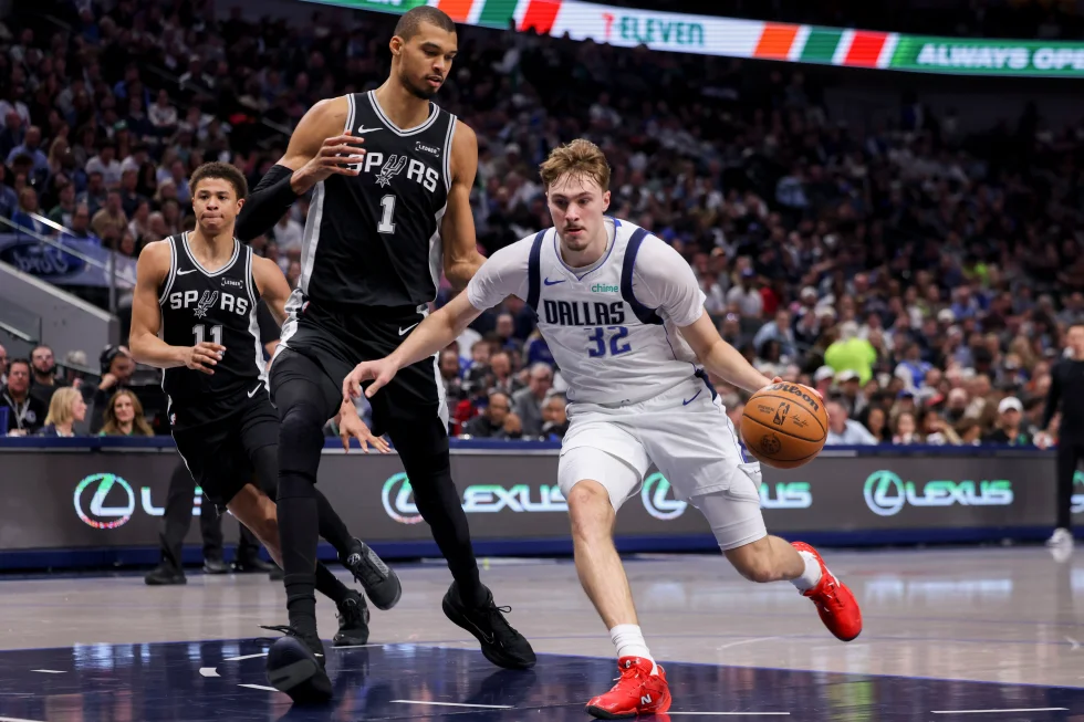 Dallas Mavericks forward Cooper Flagg (32) drives to the basket against San Antonio Spurs forward Victor Wembanyama (1) in the first half of an NBA basketball game, Thursday, Feb. 5, 2026, in Dallas. (AP Photo/Gareth Patterson)