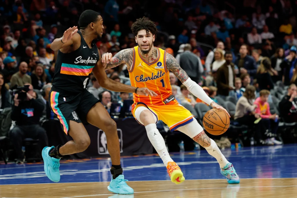 Charlotte Hornets guard LaMelo Ball (1) drives against San Antonio Spurs guard De'aaron Fox during the second half of an NBA basketball game in Charlotte, N.C., Saturday, Jan. 31, 2026. (AP Photo/Nell Redmond)