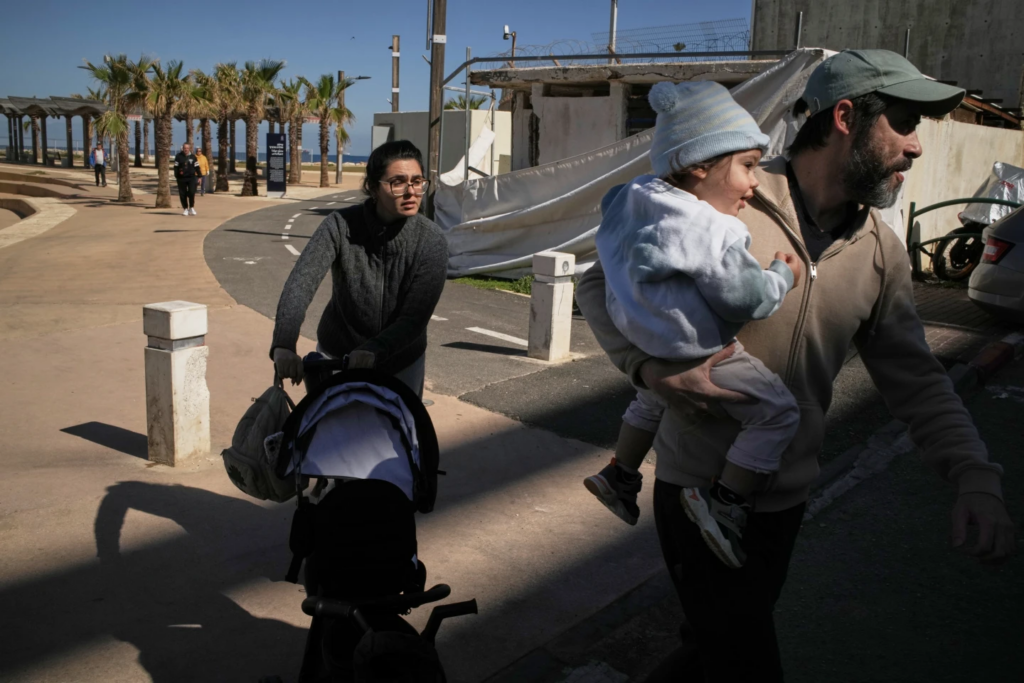 A couple with their two children rush to a shelter after a warning siren sounds following Israeli strikes in Iran, in Haifa, northern Israel, Saturday, Feb. 28, 2026. (AP Photo/Leo Correa) 