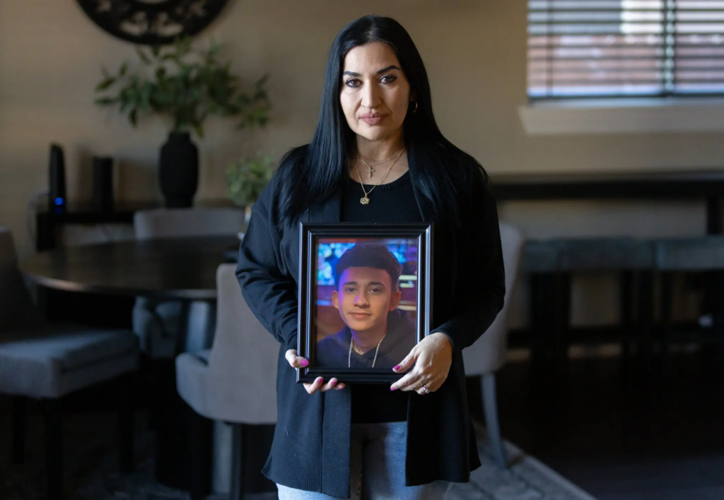 Rachel Reyes, the mother of Ruben Ray Martinez, holding a photo of her son. Mr. Martinez was shot and killed by an Immigration and Customs Enforcement officer last year.Credit...Scott Ball for The New York Times
