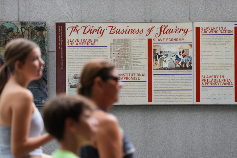 People walk past an informational panel at President's House Site Tuesday, Aug. 19, 2025, in Philadelphia. (AP Photo/Matt Rourke, File)
