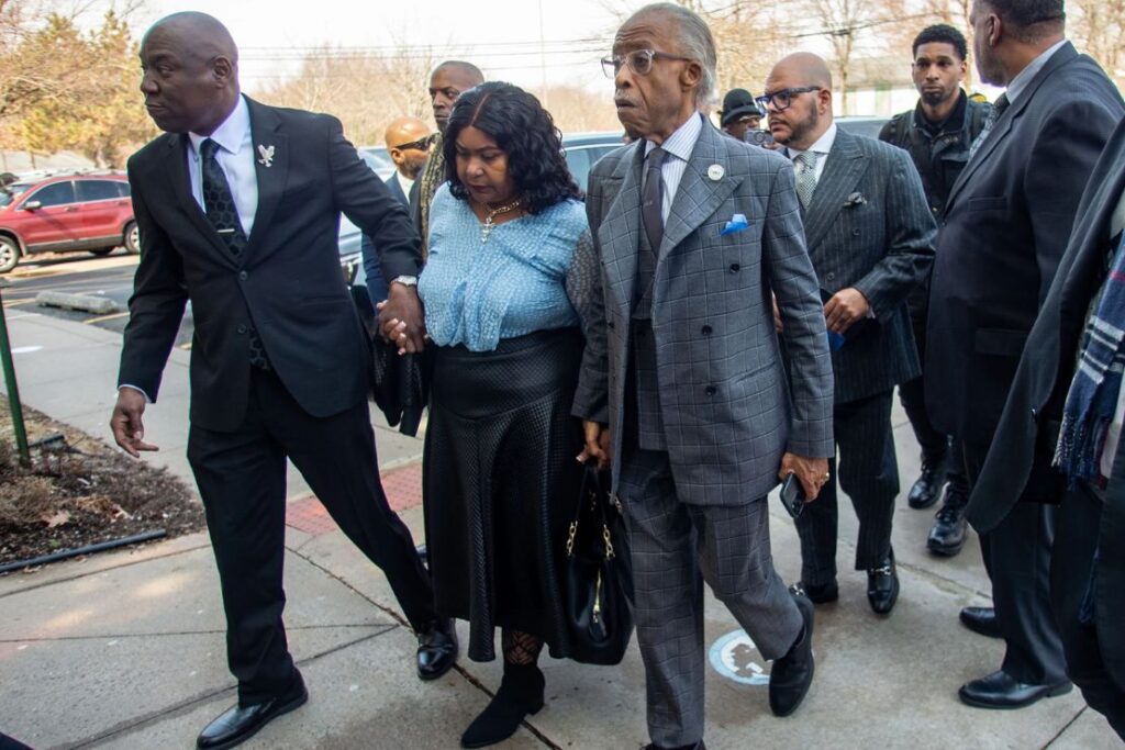 Attorney Ben Crump, left, and the Rev. Al Sharpton escort Audrey Jones, sister of Steven Jones, a man in a mental health crisis who was shot by police, into The First Cathedral for Jones’s funeral service, Thursday, March 26, 2026 in Bloomfield, Conn. (Aaron Flaum/Hartford Courant via AP)