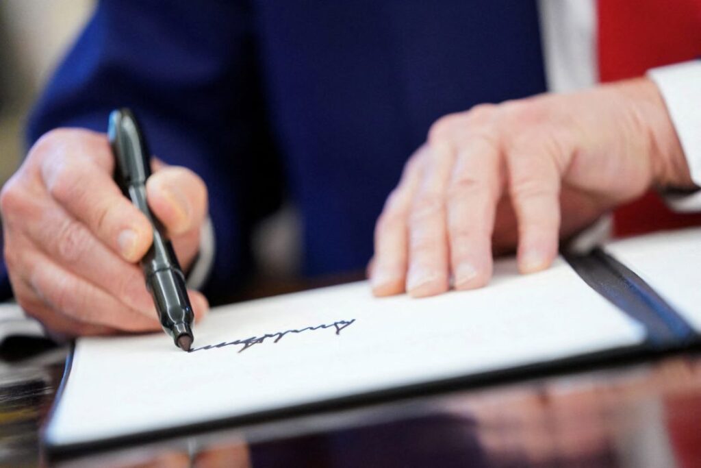 President Donald Trump writes his signature, as he signs executive orders and proclamations in the Oval Office at the White House in Washington, DC, on April 9, 2025. Nathan Howard/Reuters/File
