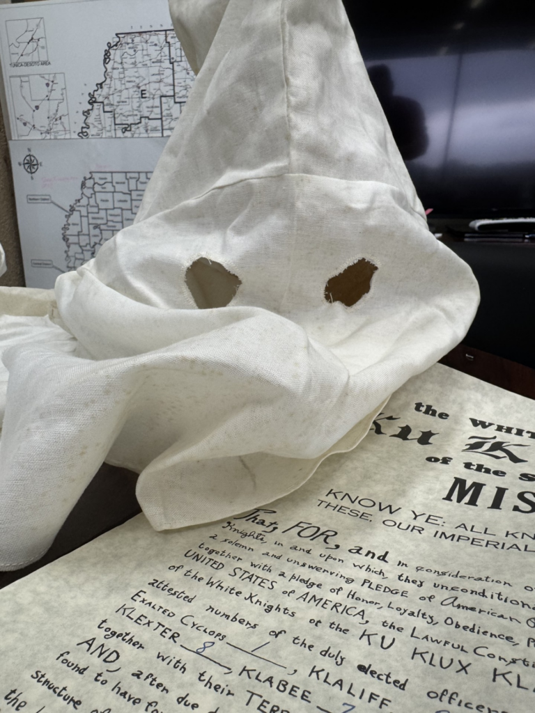 A Ku Klux Klan mask and the handwritten charter for the organization's Mississippi chapter of the White Knights were found in evidence archives of the state Department of Public Safety. Credit: Courtesy of Department of Public Safety