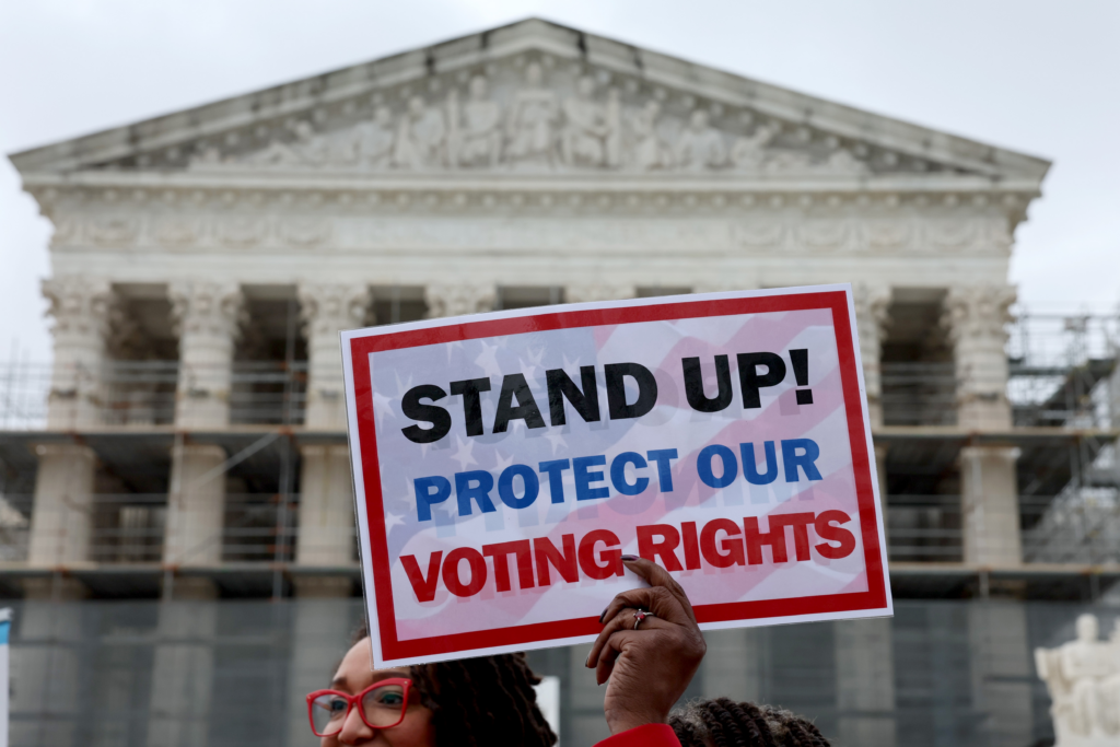 A member of Delta Sigma Theta sorority holds up a sign saying "STAND UP! PROTECT OUR VOTING RIGHTS" outside the U.S. Supreme Court on March 24 in Washington, D.C. Jemal Countess/Getty Images for Legal Defense Fund
