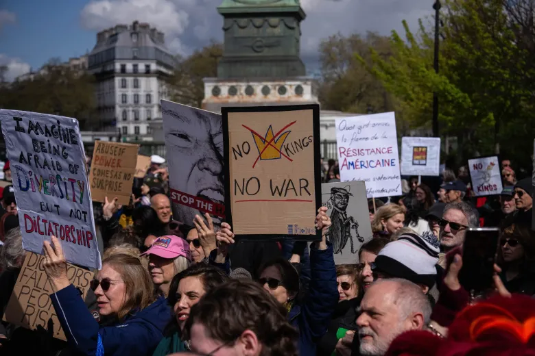 A woman holding a banner reading “No Kings, No War” takes part in the “No Kings” protest in Paris on Saturday. Credit: Aurelien Morissard / Associated Press