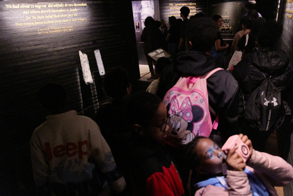  School children visit the National Museum of African American History and Culture’s Middle Passage exhibit, including a wooden timber, the artifact at back left, from the slave ship, the São José-Paquete de Africa, Friday, March 6, 2026, in Washington. (AP Photo/Jacquelyn Martin)
