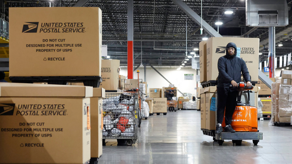 A U.S. Postal Service employee transports parcels for distribution during the start of the holiday mail rush, inside the Los Angeles Mail Processing & Distribution Center on December 2, 2025 in Los Angeles, California.  (Photo by Mario Tama/Getty Images)
