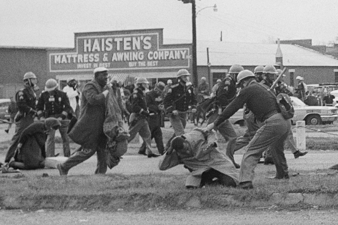 State troopers hit protesters with billy clubs to break up a civil rights voting march in Selma, Ala., on Sunday, March 7, 1965. (AP Photo/File)