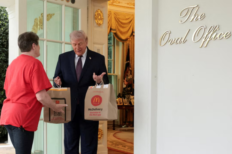 U.S. President Donald Trump receives a McDonald's delivery via DoorDash from Sharon Simmons outside the Oval Office at the White House, in Washington, D.C., U.S., April 13, 2026. REUTERS/Jonathan Ernst