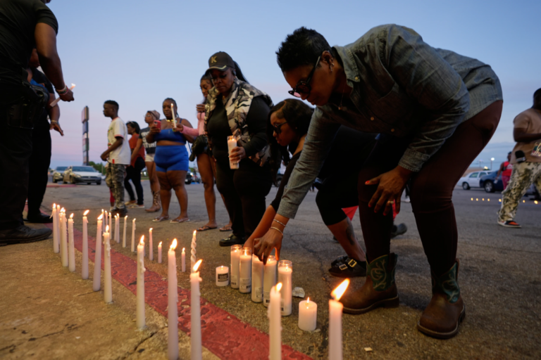 People light candles during a prayer vigil for the victims of a mass shooting earlier in the day, Sunday, April 19, 2026, in Shreveport, La. (AP Photo/Gerald Herbert)