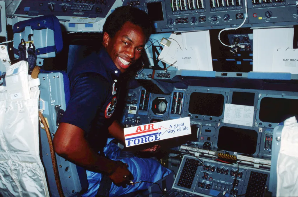 Guion “Guy” S. Bluford sits in the commander’s seat on the forward flight deck of Space Shuttle Challenger during the STS 8 mission, displaying a U.S. Air Force decal. Selected as part of NASA’s Astronaut Group 8 in 1978, Bluford went on to complete four shuttle flights and rose to the rank of colonel. Courtesy of NASA.