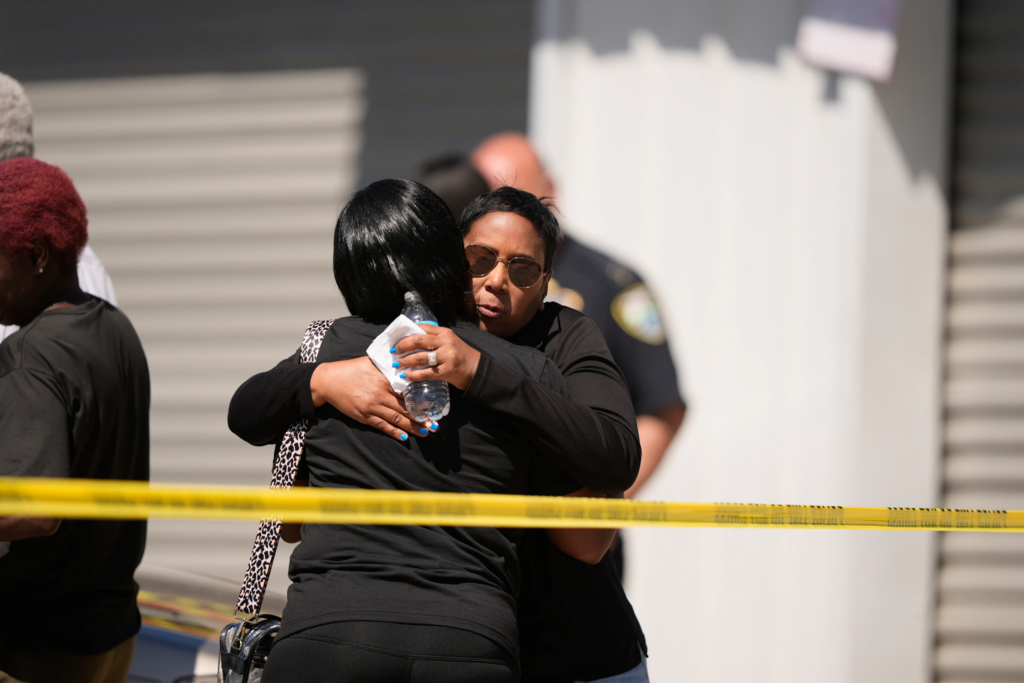 Council woman Tabatha Taylor, right, hugs an unknown person outside the scene of a mass shooting in Shreveport, La., Sunday, April 19, 2026. (AP Photo/Gerald Herbert)