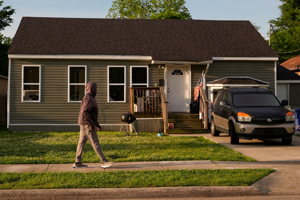 A person passes the home where a mass shooting occurred the day before in Shreveport, La., Monday, April 20, 2026. (AP Photo/Gerald Herbert)