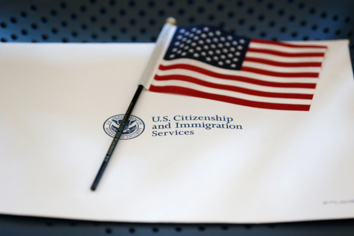 An information packet and an American flag are placed on a chair at the U.S. Citizenship and Immigration Services Miami Field Office on Aug. 17, 2018, in Miami. (AP Photo/Wilfredo Lee, File)