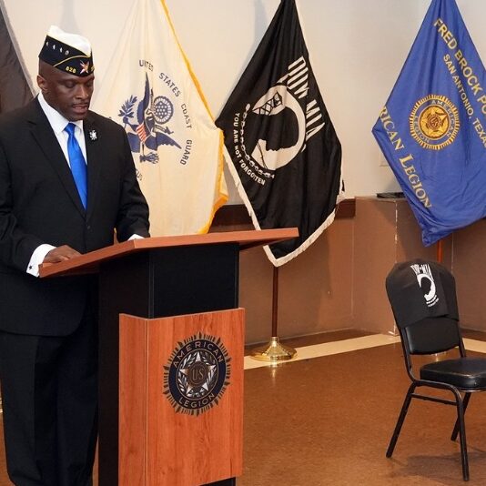 First Vice Commander Billy Hill narrates the Memorial Table Candle-lighting Ceremony to honored American POW/MIAs and servicemen and women who have departed during the Memorial Day Ceremony (Photo by Legionnaire Burrell Parmer/TEXALPA)