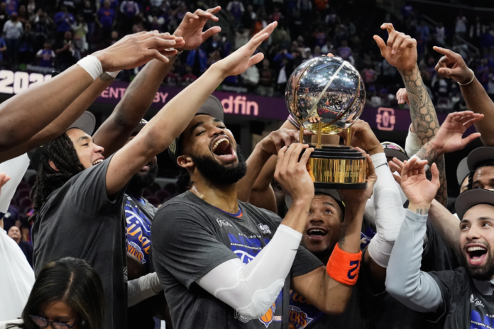 New York Knicks center Karl-Anthony Towns, center, and teammates celebrate after winning Game 4 in the Eastern Conference finals NBA basketball playoffs series against the Cleveland Cavaliers in Cleveland, Monday, May 25, 2026. (AP Photo/Sue Ogrocki)