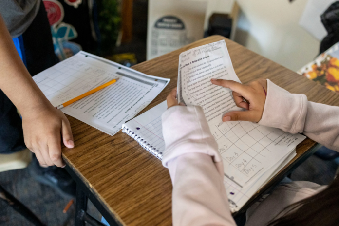 Sixth graders read a passage and give constructive feedback to their partners during Nancy Barajas' class at Fairview Elementary School on Wednesday, May 6, 2026, in Modesto, Calif. (AP Photo/Annie Barker)
