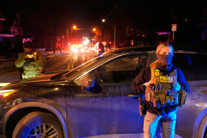 Federal immigration officers at the scene of a reported shooting Wednesday, Jan. 14, 2026, in Minneapolis. (AP Photo/John Locher, File)