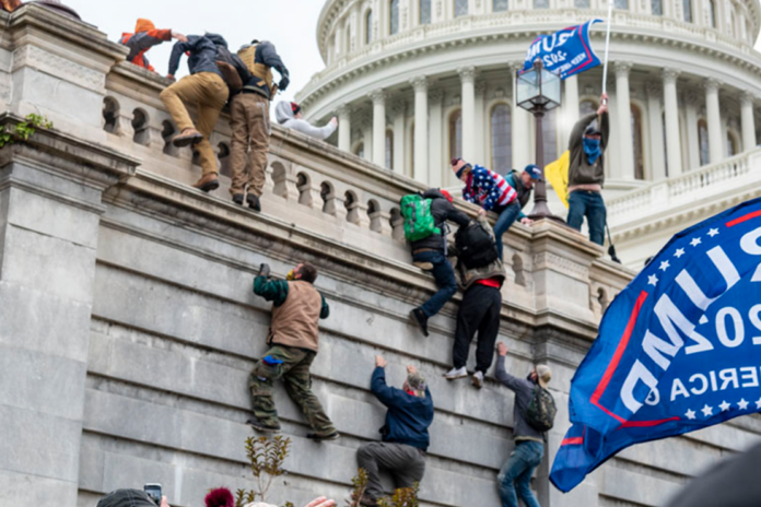 Trump supporters climb the west wall of the Capitol on Jan. 6. Via AP