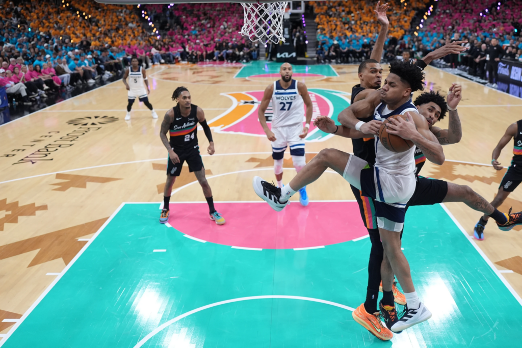 Terrence Shannon Jr. (1), front, handles the ball as San Antonio Spurs guard Dylan Harper (2), middle, and forward-center Victor Wembanyama (1), back, defend during the second half in Game 1 of a second-round NBA playoffs basketball series in San Antonio, Monday, May 4, 2026. (AP Photo/Eric Gay)